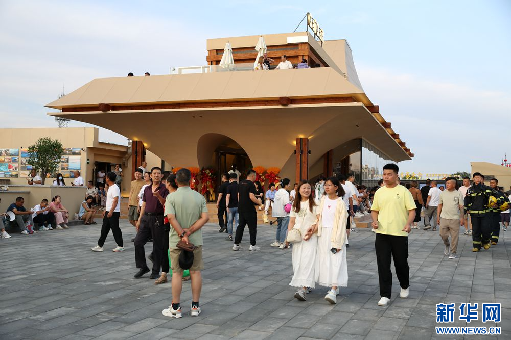 6月22日傍晚,游客在包头“天下黄河第一村”游玩。新华网 石毅 摄