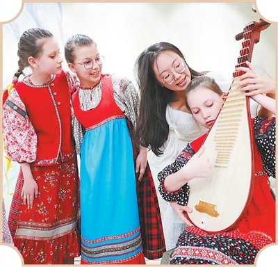 俄罗斯少年在满洲里体验学习弹奏琵琶。 王化勇摄