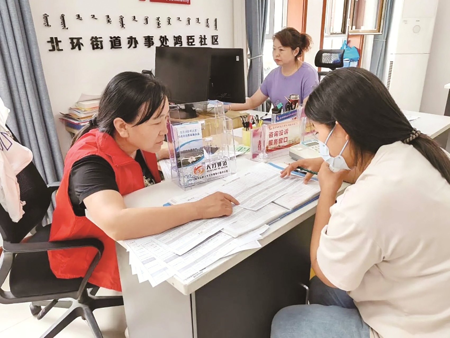 工作人员给居民讲解就业政策