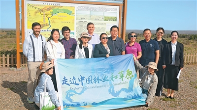 在乌兰布和沙漠黄河岸线流沙联防联治示范区,各国嘉宾与治沙工作人员合影。