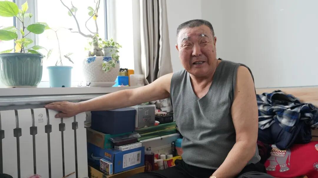 鄂温克族自治旗巴彦塔拉达斡尔民族乡幸福互助养老院杜金柱老人抚摸着发热的暖气片 梁燕摄 鄂温克族自治旗巴彦塔拉达斡尔民族乡幸福互助养老院杜金柱老人