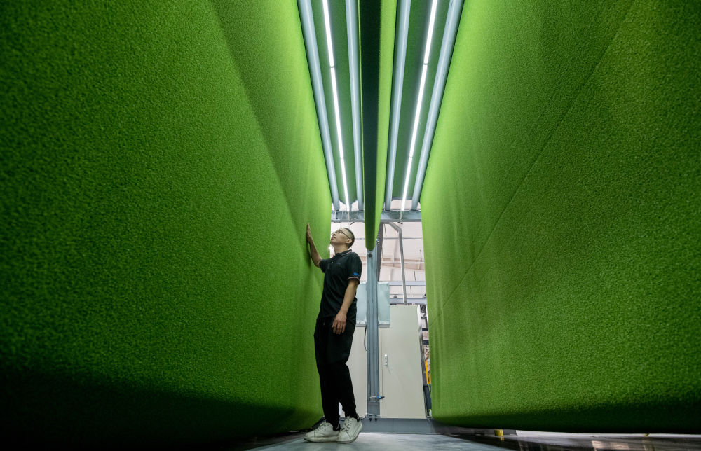 在山东省乐陵市泰山体育产业集团人造草坪智能化生产车间,工人在检测产品。新华社记者 范长国 摄