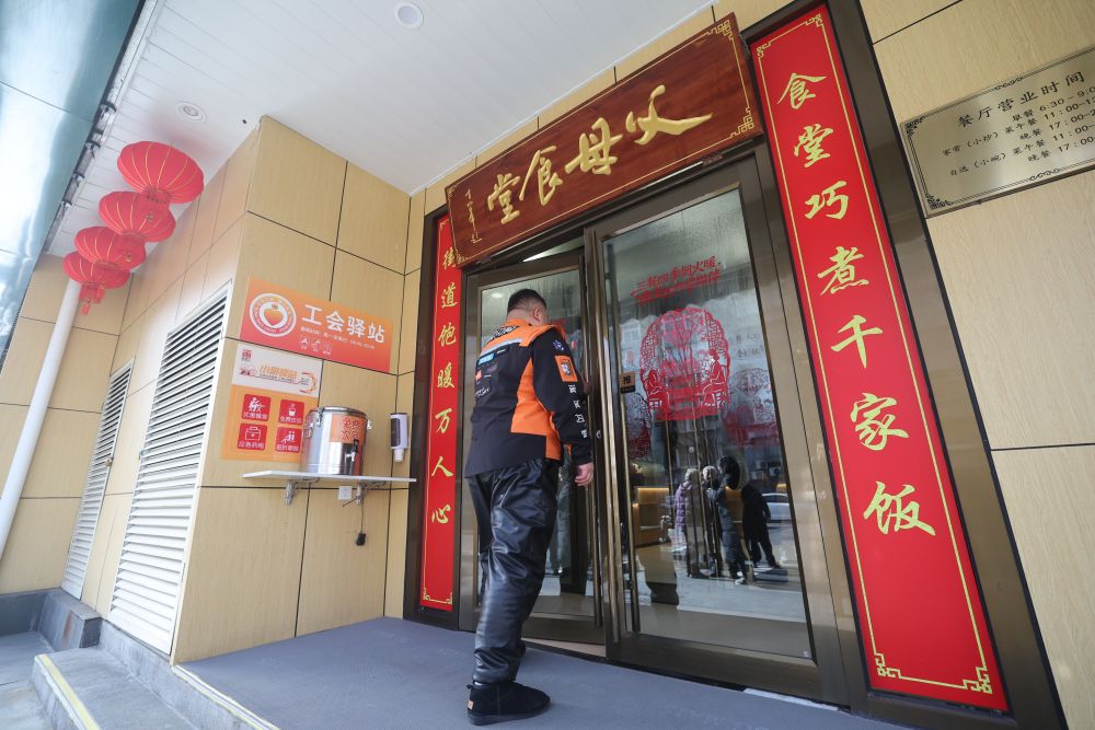 2月10日,一名快递员走进新街口街道父母食堂。