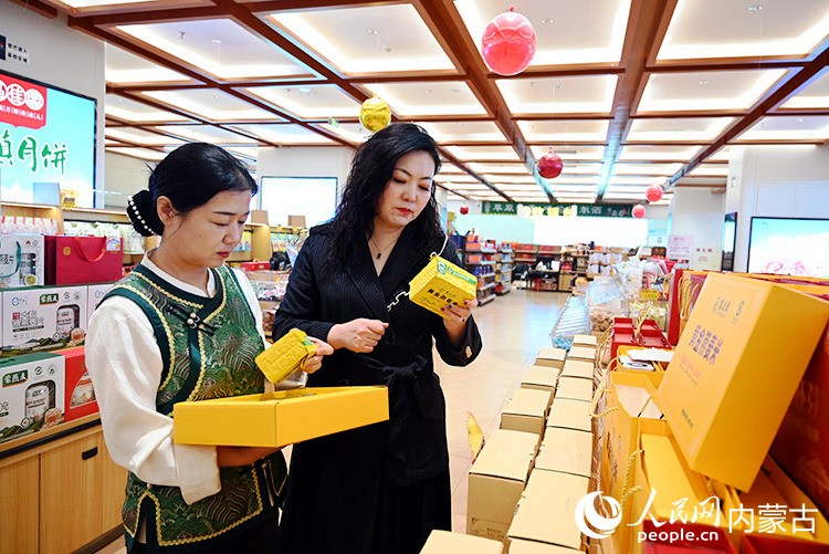 马慧平（右）和店员正在理货。人民网记者 刘艺琳摄